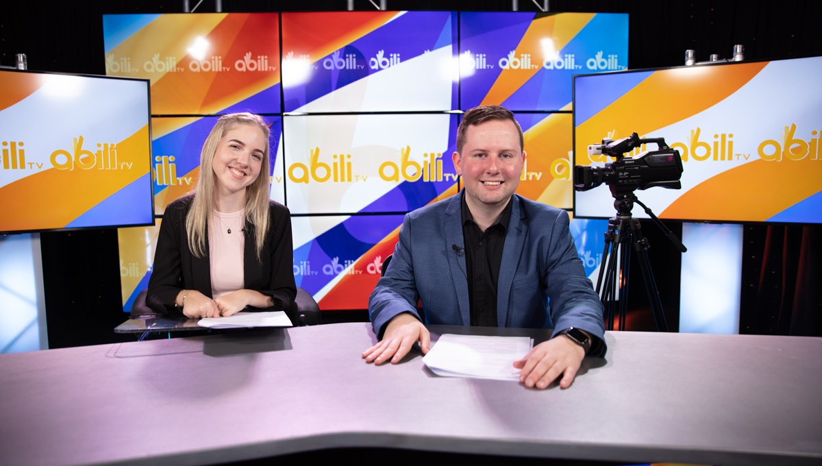 Photo of male and female news anchors posing inside the studio for AbiliTV show.