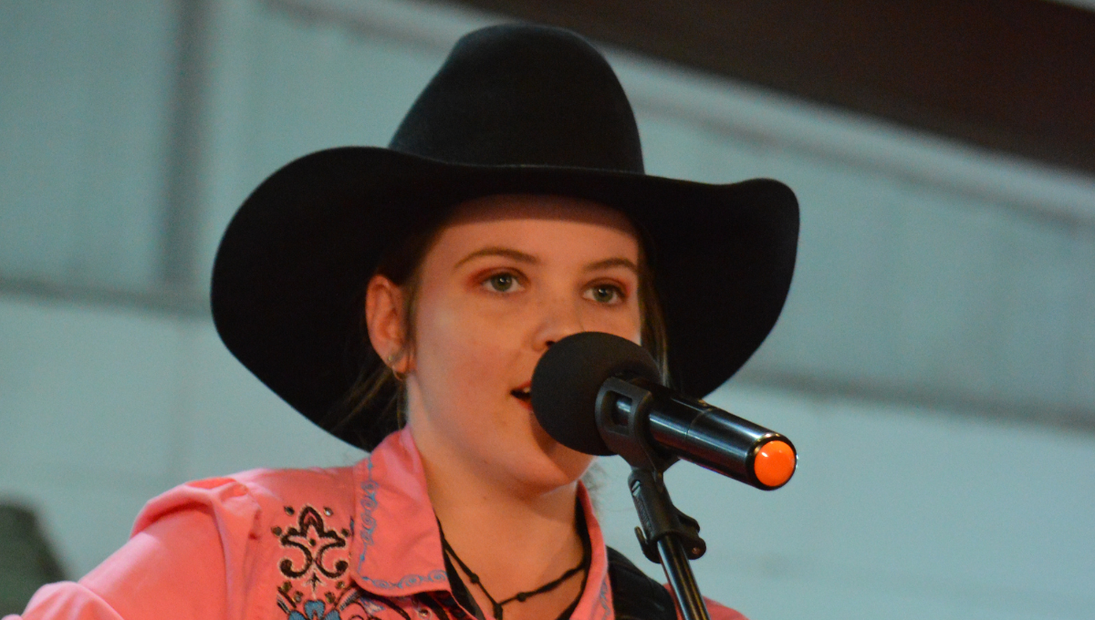 Photo of Hayley Anderson in country wear performing on stage